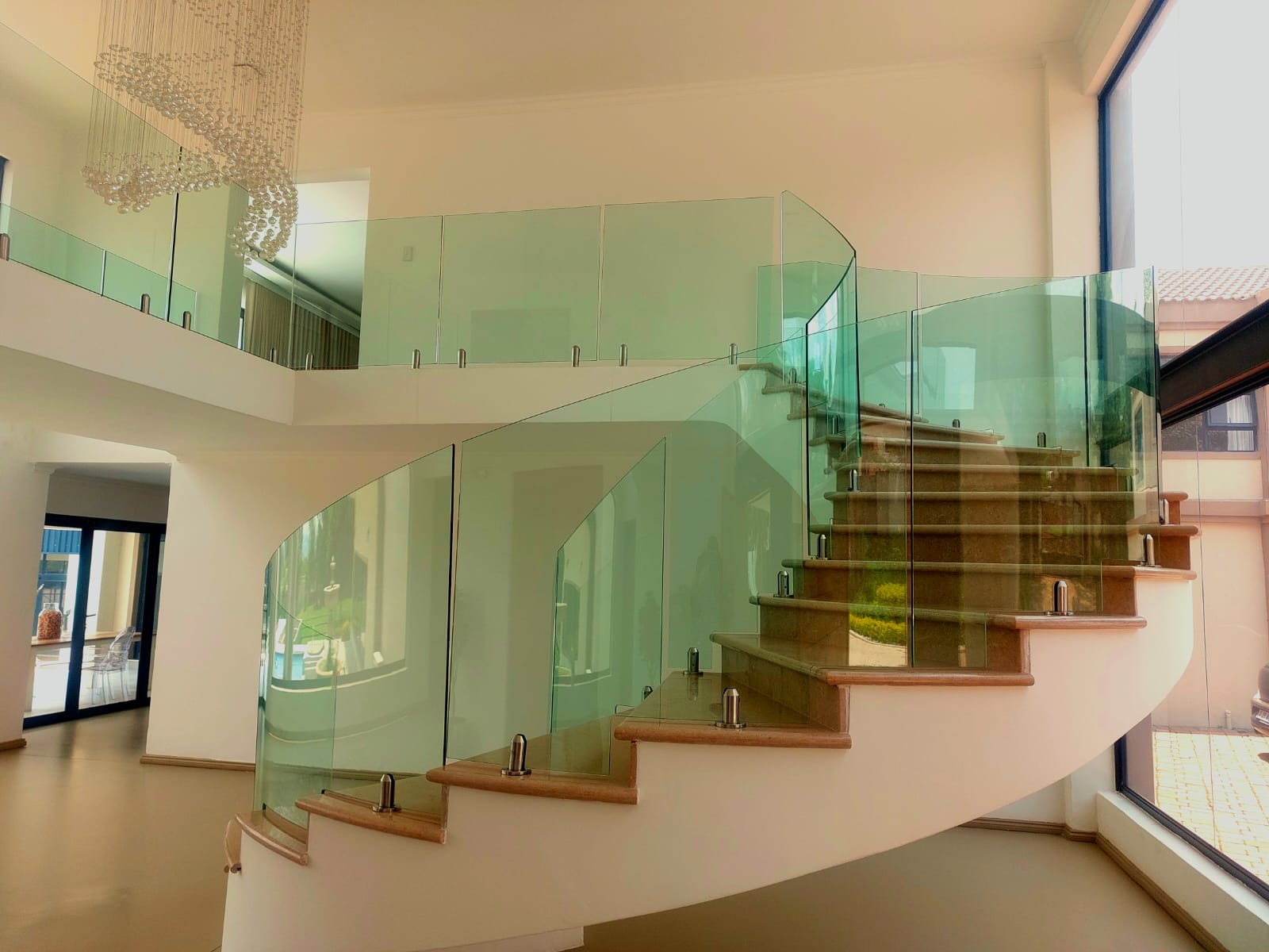 Curved glass balustrade staircase with stainless steel fittings